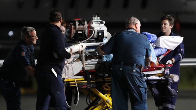 An injured mine worker is transferred from an air ambulance to be taken to hospital in Brisbane on Wednesday night. Picture: Josh Woning/AAP