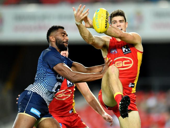 Sam Collins (right) of the Suns contests the ball against Esava Ratugolea (left) of the Cats during the AFL Marsh Community Series pre-season match between the Gold Coast Suns and Geelong Cats at Metricon Stadium on the Gold Coast, Saturday, February 22, 2020. (AAP Image/Darren England)