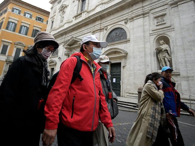 Tourists wearing protective masks past the Church of St. Louis of the French (San Luigi dei Francesi) in Rome. Picture: AFP