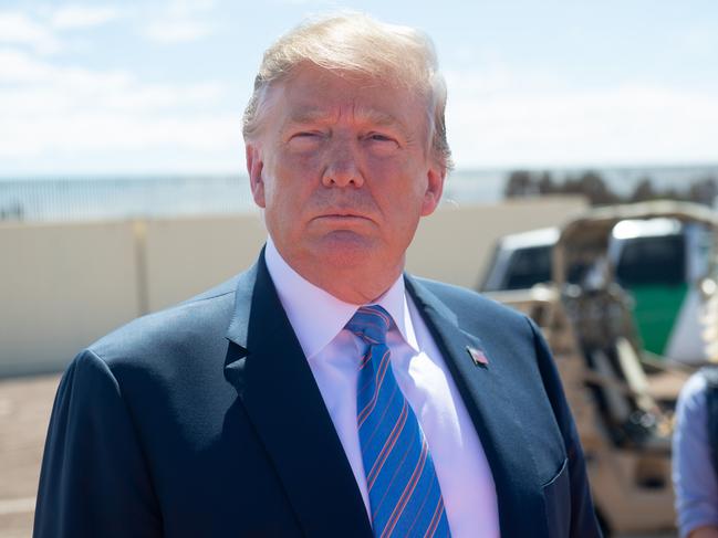 US President Donald Trump speaks with members of the US Customs and Border Patrol as he tours the border wall between the United States and Mexico in Calexico, California on April 5, 2019. - President Donald Trump landed in California to view newly built fencing on the Mexican border, even as he retreated from a threat to shut the frontier over what he says is an out-of-control influx of migrants and drugs. (Photo by SAUL LOEB / AFP)