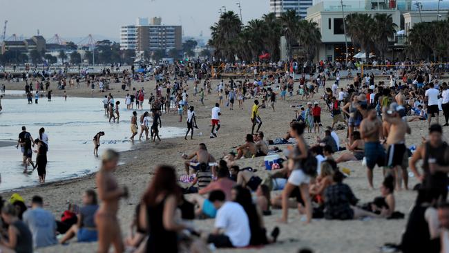 Crowds gather at St Kilda Beach to escape the heat and to watch the sunset.