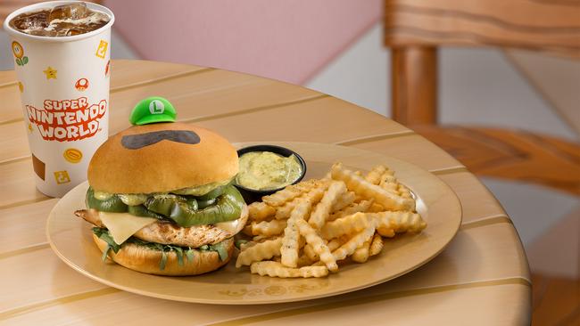 This is the Luigi Burger (Pesto Grilled Chicken) from the Toadstool Cafe – grilled chicken topped with basil pesto, melted Swiss cheese, green peppers, and fresh spinach, all served on a soft brioche bun with a side of Truffle French fries. Photo: Universal Epic Universe