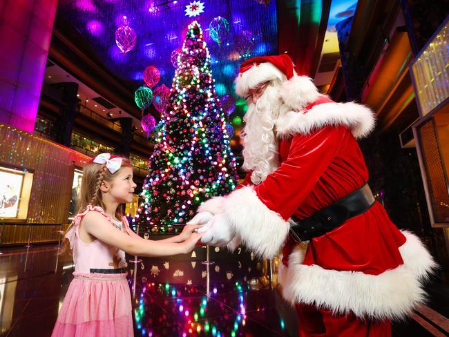 Santa talks to Grace, 6, about what she wants for Christmas at the Christmas tree at Crown Atrium. Picture: David Caird