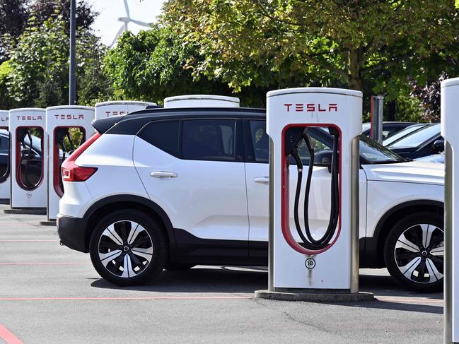 A Tesla electric vehicle charges at a station in Nivelles, on August 26, 2024. (Photo by ERIC LALMAND / Belga / AFP) / Belgium OUT