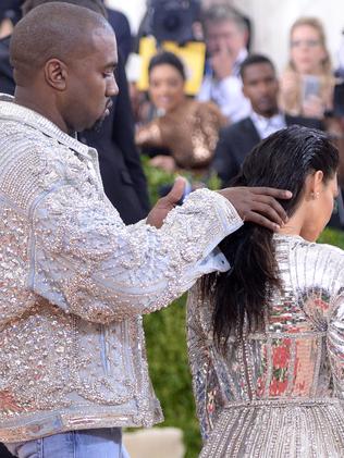 Kanye West fusses over wife Kim Kardashian West's hair. Picture: AP