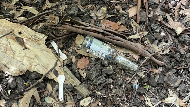 Empty bottles of alcohol littered around bushes. Picture: Himangi Singh