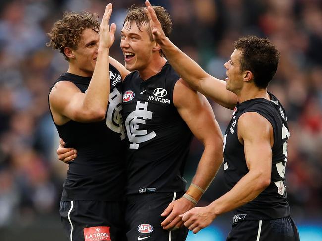 MELBOURNE, AUSTRALIA - MAY 12: Charlie Curnow of the Blues (left) celebrates on the final siren with Patrick Cripps of the Blues (middle) and brother Ed Curnow of the Blues (right) during the 2018 AFL round eight match between the Carlton Blues and the Essendon Bombers at the Melbourne Cricket Ground on May 12, 2018 in Melbourne, Australia. (Photo by Adam Trafford/AFL Media/Getty Images)