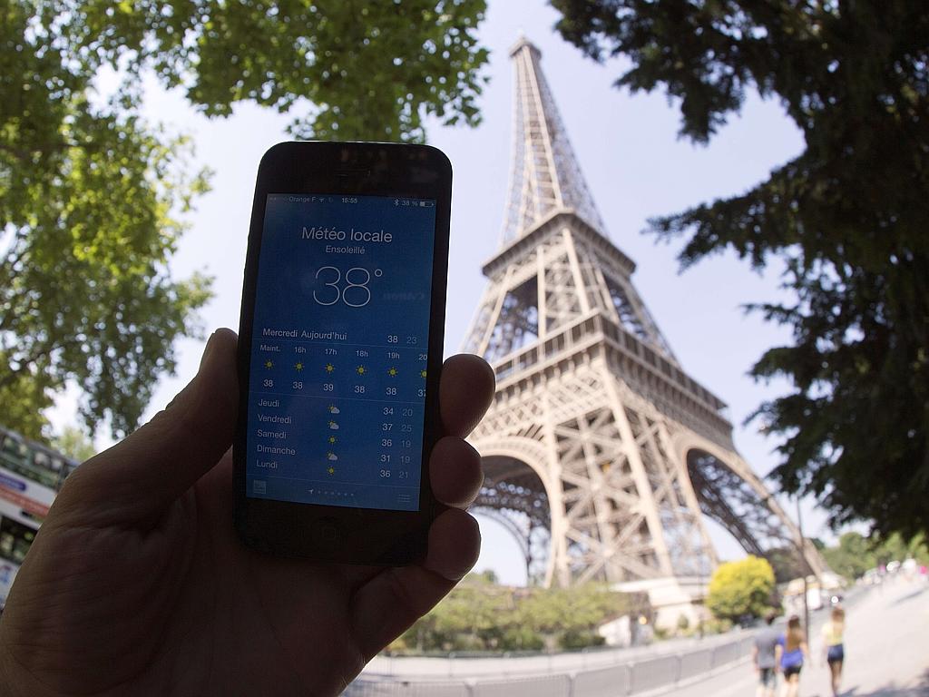 An illustration picture shows a person holding a smartphone indicating 38 degrees celsius for Paris’ temperature on July 1, 2015 near the Eiffel Tower in Paris, as a heatwave sweeps through Europe. Picture: AFP