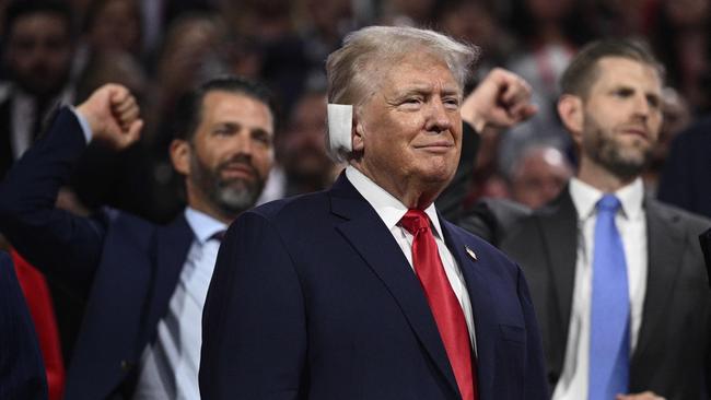 Donald Trump looks on as his sons Donald Trump Jr. and Eric Trump gesture behind him. Picture: Brendan Smialowski/AFP