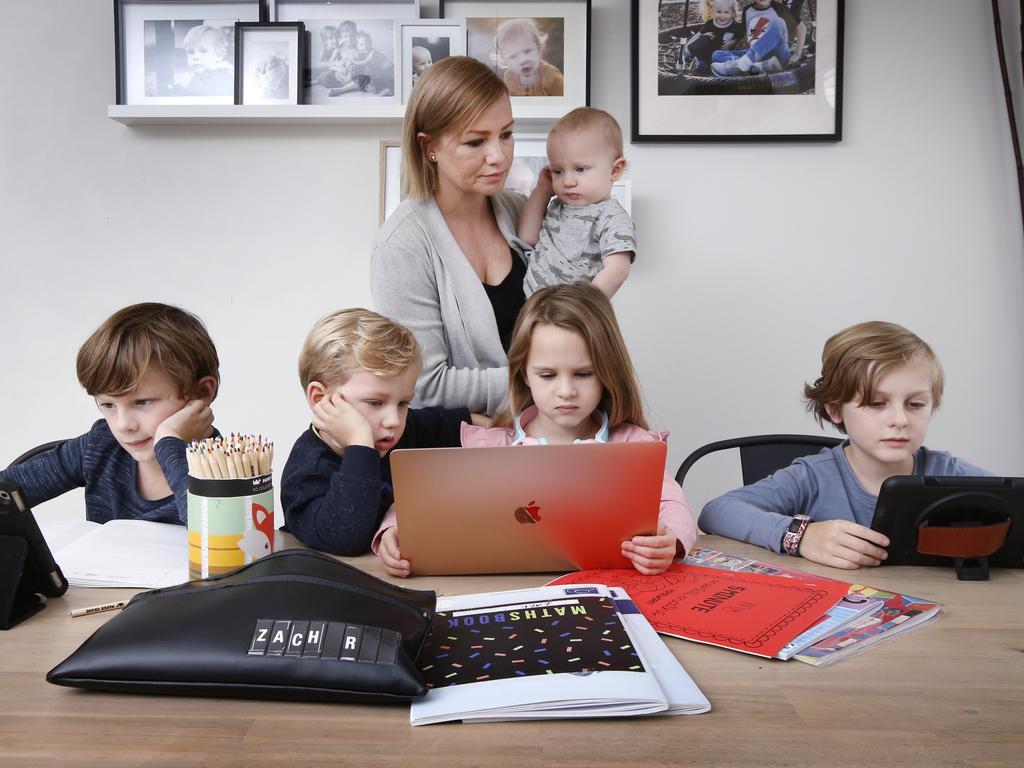 Carly Ravenhall has five children home and says while it is not a popular opinion, she is loving it. She is pictured holding Finn, 1, Zach, 9, Noah, 3, Lexi, 6, and Oscar, 8. Picture: David Caird