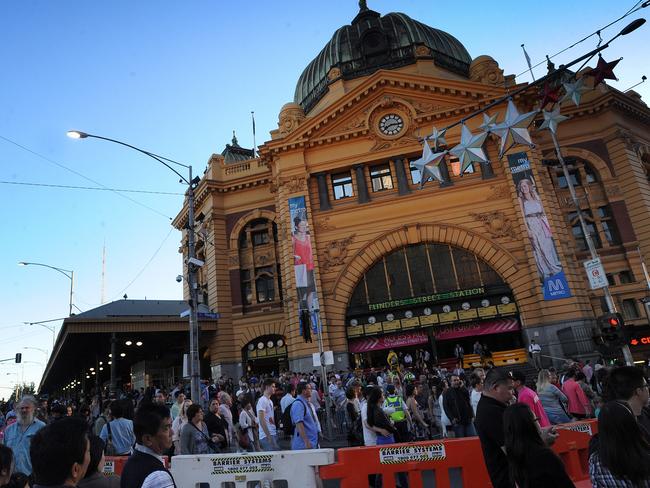 Onlookers walk around the CBD before the early fireworks, in the lead up to the mid-night New Year celebrations in Melbourne, Monday, Dec. 31, 2012. (AAP Image/Joe Castro) NO ARCHIVING