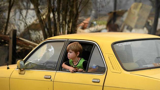 One of the Collier children sits in the Gemini among the ruins of his home. Picture: Marc Stapelberg