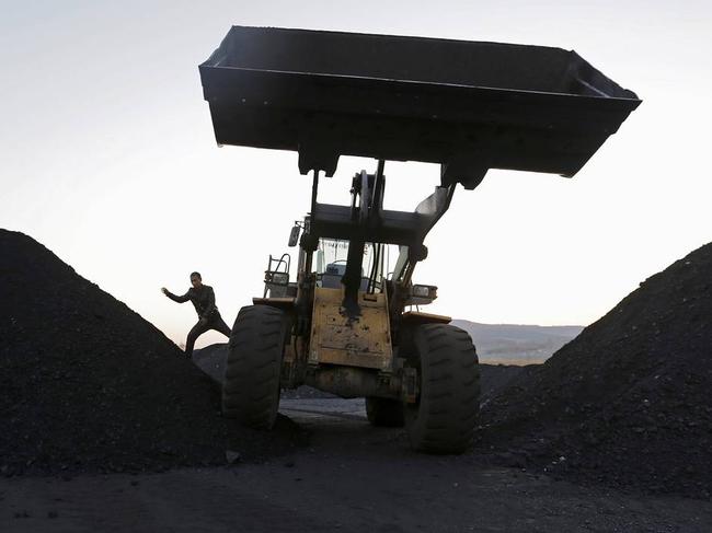 A driver jumps off a loading vehicle at a coal depot on the outskirts of Jixi, in Heilongjiang province, China, Oct. 23, 2015. PHOTO: JASON LEE/REUTERS