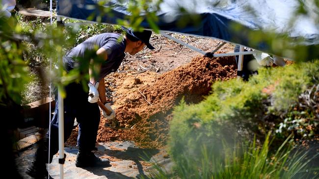 NSW Police and Forensic Services personnel are seen sifting through dirt as they search the former home of missing woman Lynette Dawson, at Bayview on the northern beaches, in Sydney. (AAP Image/Dan Himbrechts)