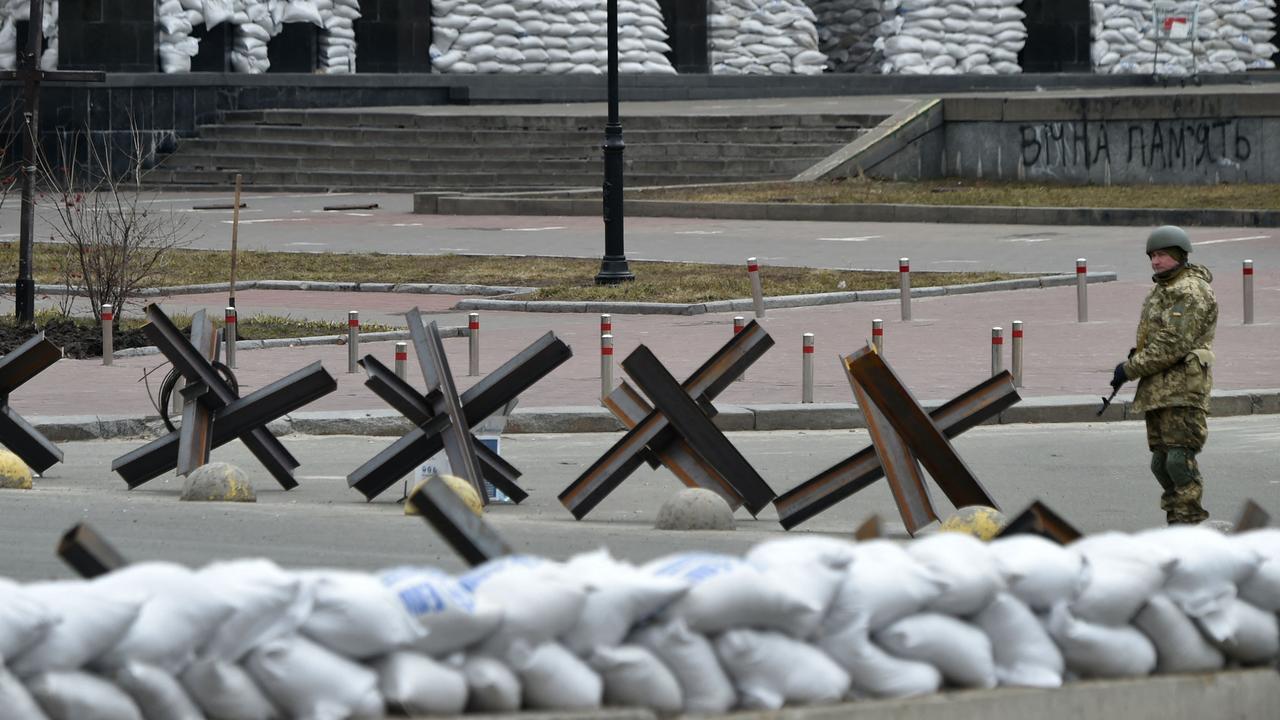 A member of the Ukrainian Territorial Defence Forces stands guard next to antitank obstacles in the centre of Kyiv. Picture: Sergei Supinsky/AFP