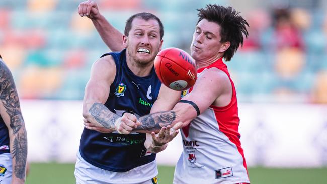 Michael Musicka fires out a handball under pressure from Clarence’s Keren Howlett earlier this season. Picture: Linda Higginson