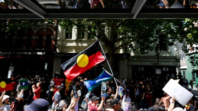 Protesters march from Parliament House to Flinders's Street Station during the Treaty Before Voice Invasion Day Protest.