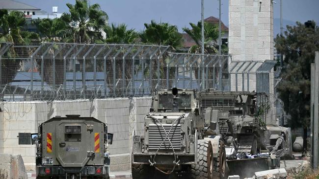 Israeli armoured vehicles including a bulldozer drive in a street during an army raid in Jenin in the occupied-West Bank on August 31. Picture: AFP