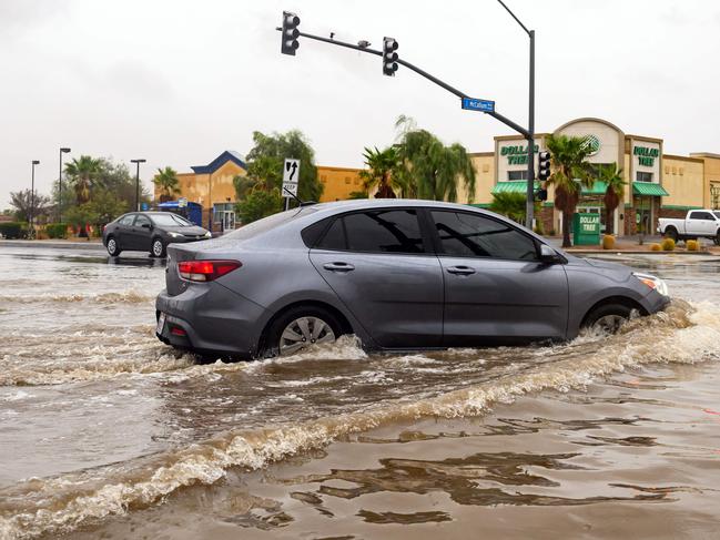 A car drives through a flooded intersection as Tropical Storm Hilary makes landfall in Palm Springs, California. Picture: AFP