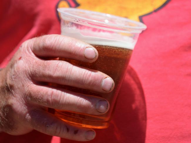 A man wearing a shirt with a smily printed on it holds a beer in his hands in Canberra, Saturday, Jan. 4, 2014. One third of all adults worldwide 1.46 billion people €”are now overweight or obese, according to a recent report from the Overseas Development Institute. (AAP Image/Lukas Coch) NO ARCHIVING