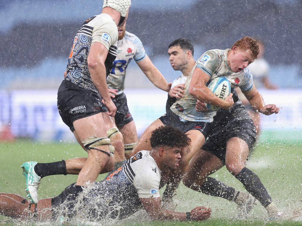 Tane Edmed of the NSW Waratahs is tackled during the round 12 Super Rugby Pacific match between NSW Waratahs and ACT Brumbies at Allianz Stadium, on May 11, 2024, in Sydney, Australia. (Photo by Cameron Spencer/Getty Images)