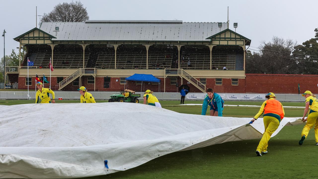 Australia’s players helped ground staff cover the Junction Oval pitch during the second ODI against the West Indies on Thursday that was eventually abandoned. Picture: Asanka Ratnayake / Getty Images