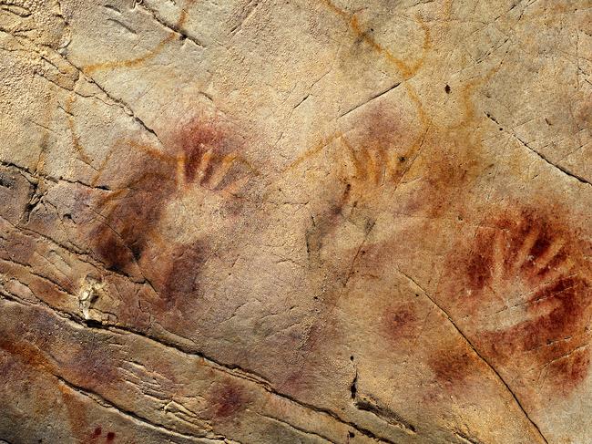 This undated handout photo provided by pedro suara/aaas shows detail of the 'Panel of Hands' cave painting in the El Castillo Cave, Spain, showing red disks and hand stencils made by blowing or spitting paint onto the wall. A date from a disk shows the painting to be older than 40,800 years making it the oldest known cave art in Europe. The bison overlies the hands and is therefore painted later. New tests show that crude Spanish cave paintings of a red sphere and handprints are the oldest in the world, so ancient they may not have been by modern man. They might have even been made by the much-maligned Neanderthals, some scientists suggest but others disagree. (AP Photo/Pedro Saura, AAAS)