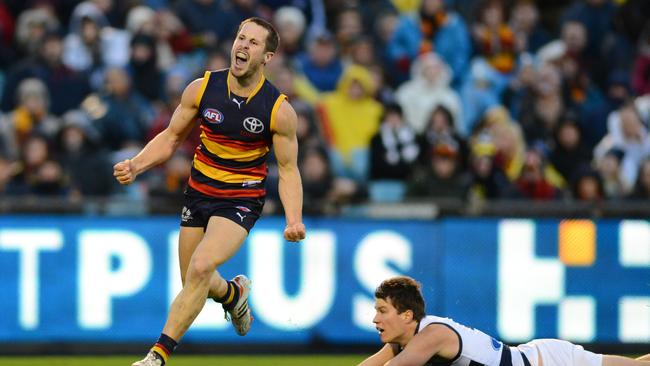 Adelaide's Matthew Wright kicks the goal to take the lead in the final quarter avoiding the tackle of Geelong's Andrew Mackie.