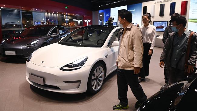 People look at Tesla Model 3 cars in a Tesla showroom in Beijing. Picture: AFP