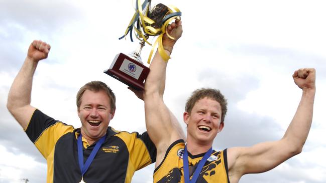 Peter Bugden and Whittlesea captain Garrett Heenan lift the 2010 premiership cup.