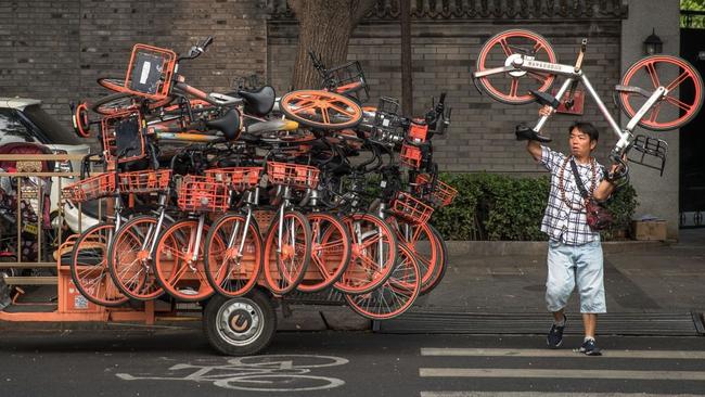 A worker loaded Mobike rental bicycles on a three-wheel vehicle in Beijing last year. Hundreds of employees have left Mobike recently, either voluntarily or through lay-offs. Picture: Roman Pilipey/EPA/Shutterstock