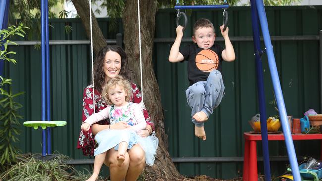 Charlotte Reimer, of Magill, with her children Chelsea, 3 and Brucey, 6, having fun on playground equipment at home. Picture: Tait Schmaal