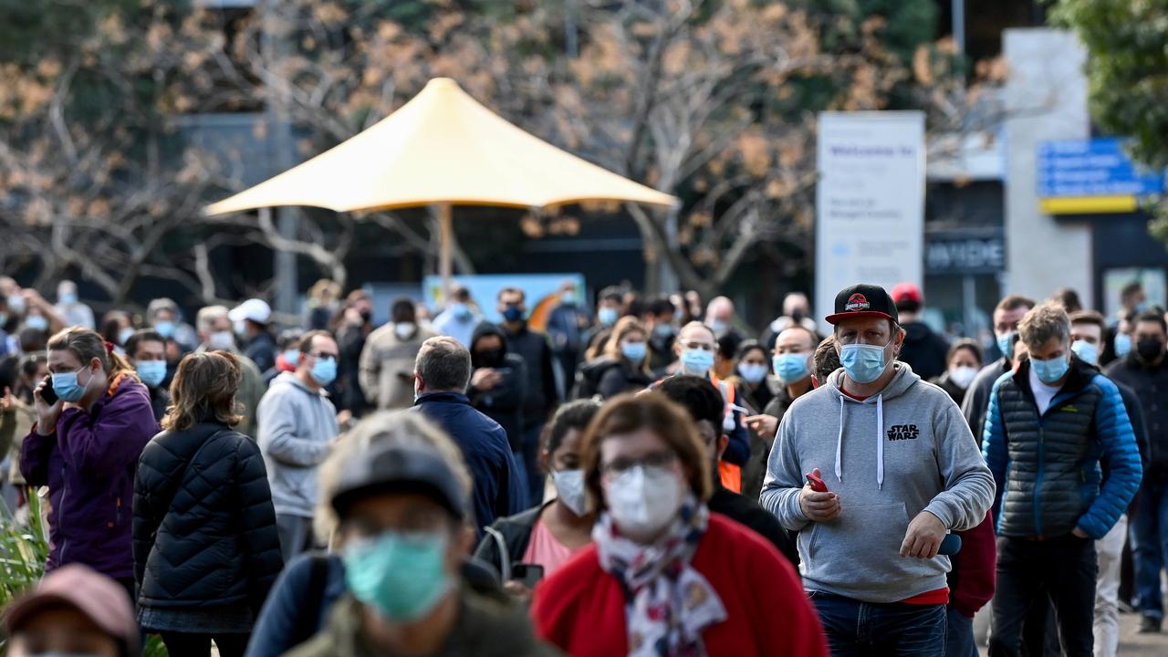 Crowds of people wearing face masks wait in line to receive a Covid-19 vaccination at the NSW vaccination hub in Sydney on Sunday.