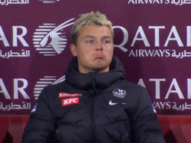 Jack Ginnivan reacts seeing himself on the big screen while injured during Collingwood's loss to Sydney.