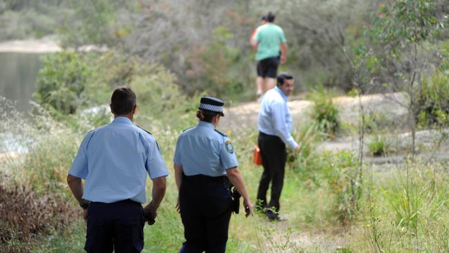 Police walk along the 2km track from the scene of the fall. Picture: Simon Bullard
