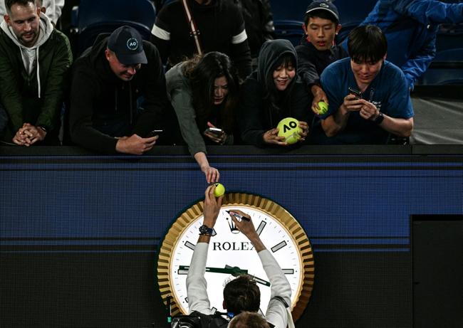 Russia's Daniil Medvedev signs autographs above the clock on Rod Laver Arena