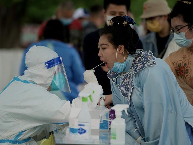 A health worker takes a swab sample at a woman to be tested for the Covid-19 coronavirus at a swab collection site in Beijing on May 1, 2022. Picture: Noel Celis / AFP.