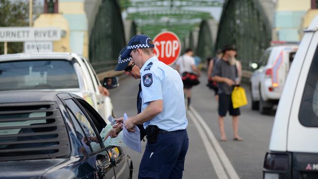 Police check residents' identification as they line up in their cars to cross the Burnett Bridge into the exclusion zone to inspect their flood damaged homes, North Bundaberg, Saturday, February. 2, 2013. Residents of the hardest hit suburb in Queensland's flood crisis had begun the heartbreaking journey of returning home to assess damage after police opened the Burnett Bridge to north Bundaberg residents at 6am. (AAP Image/Paul Beutel) NO ARCHIVING