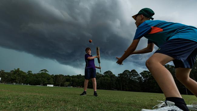 Wil Murray 12 and Oscar Creber 12 play cricket under a storm cell approaching Yandina. Picture Lachie Millard