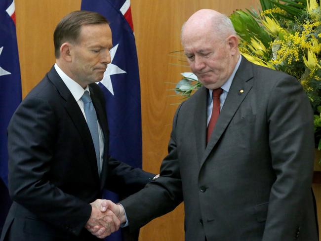 A grim-looking PM Tony Abbott with Governor-General Sir Peter Cosgrove after signing an MH17 condolence book in Canberra yesterday.