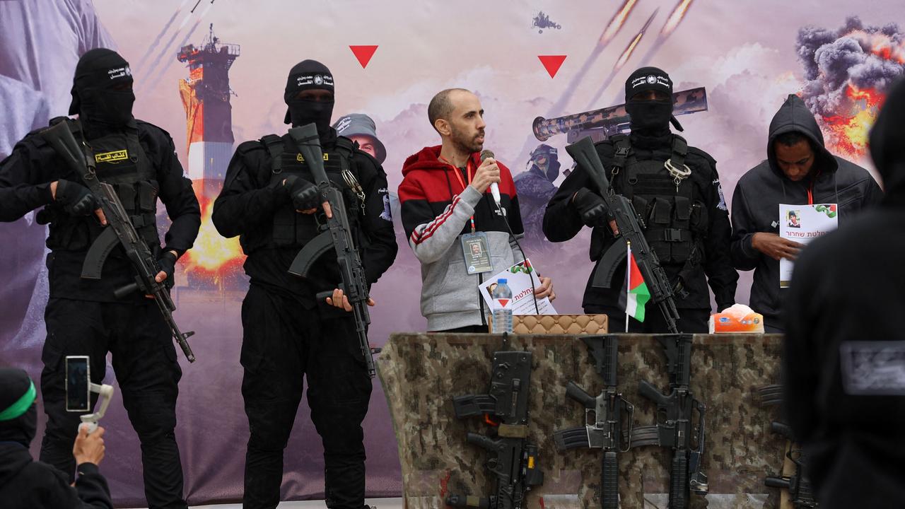 Israeli hostages Avera Mengistu (R) and Tal Shoham (3rd-L) are flanked by Palestinian Hamas fighters as they stand on a stage during their release in Rafah in the southern Gaza Strip on February 22, 2025. Picture: Omar AL-QATTAA / AFP