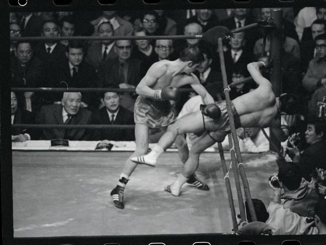 Japanese challenger Fighting Harada is knocked through ropes by defending champ Johnny Famechon of Australia in the 14th round of their world featherweight title bout.