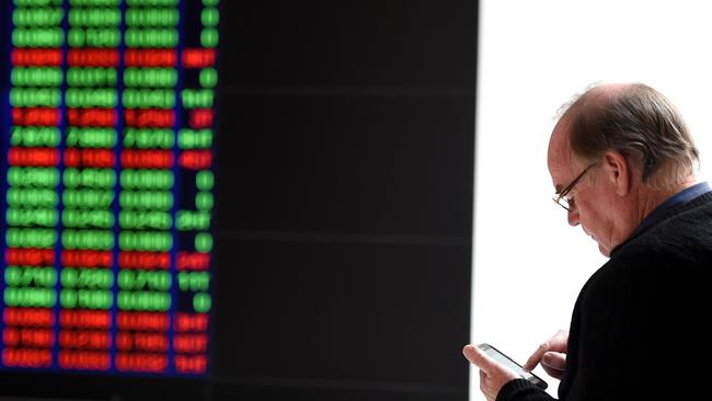 A man watches the ASX trading board in Sydney on Tuesday, Aug. 25, 2015. After an initial 1.5 per cent plunge, the S&P/ASX 200 and the All Ordinaries which pulled both indices below 5,000 points, a recovery among key heavyweight bank stocks pushed the market back into positive territory. (AAP Image/Paul Miller) NO ARCHIVING