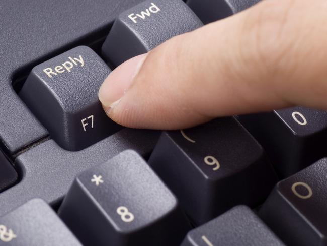 Closeup of a finger pressing REPLY button on a keyboard. Thinkstock