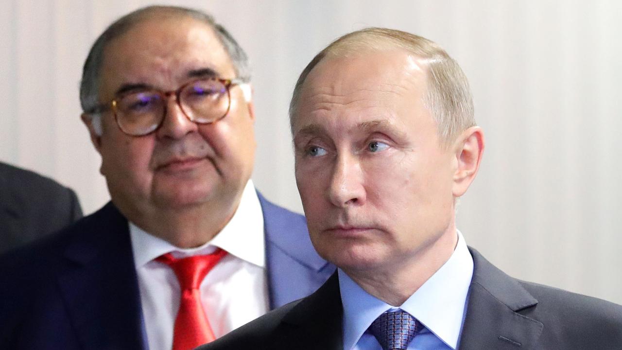 Alisher Usmanov (left) reportedly has close ties to Vladimir Putin. (Photo by Michael Klimentyev / Sputnik / AFP)