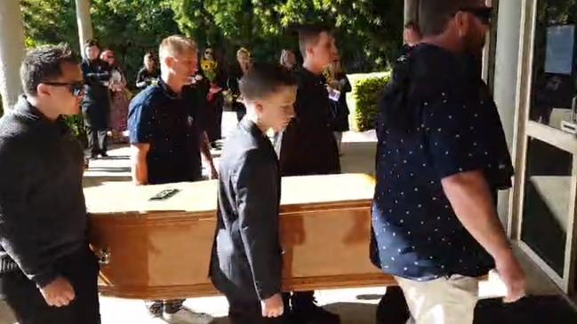 Family and friends carry in the casket in to the chapel at Mt Gravatt.