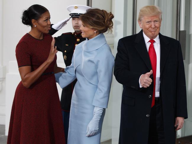 Incoming President Donald Trump gives a thumbs-up as first lady Michelle Obama and Melania Trump talk at the White House in Washington on January 20, 2017. Picture: AP