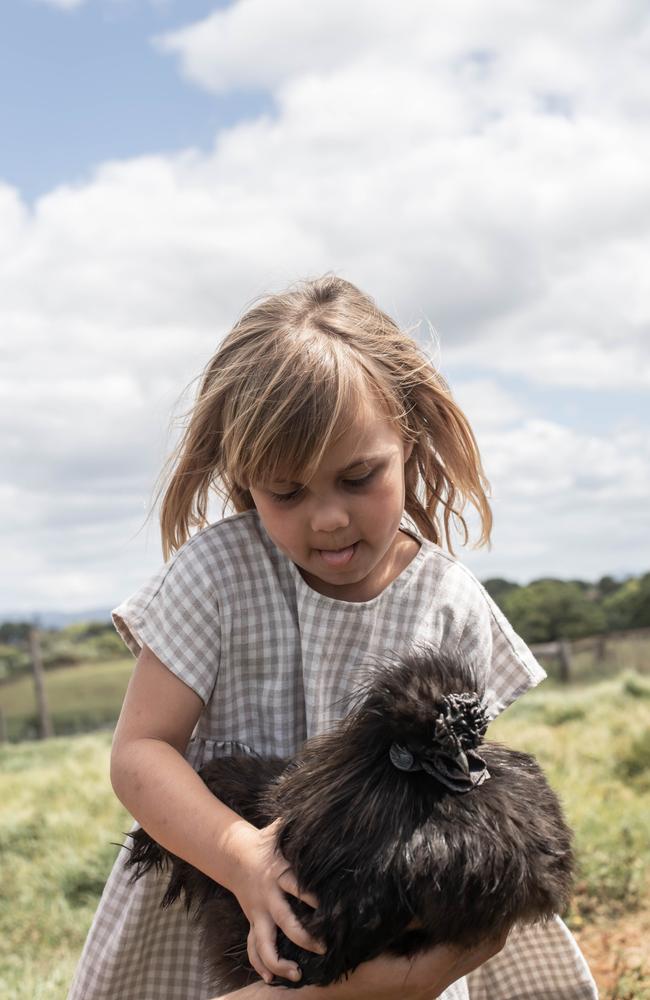 Freya Martinot, 5, carries a chicken at The Farm Byron Bay. Picture: supplied.