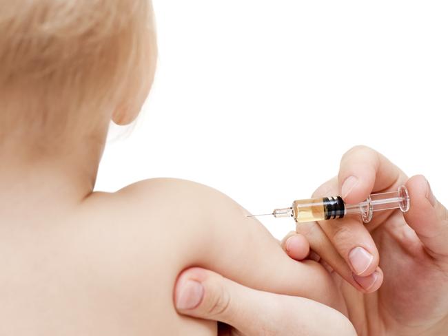 Doctor giving a child an intramuscular injection in arm, shallow DOF