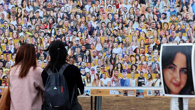 Israelis visit a memorial bearing portraits of people taken hostage or killed in the Hamas attack on the Supernova music festival on October 7. Picture: AFP